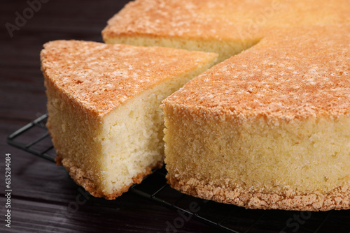 Tasty sponge cake on wooden table, closeup