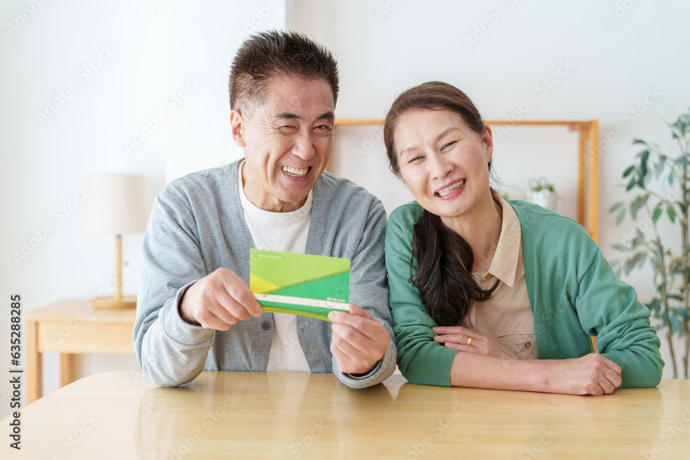 通帳を見て微笑むシニア夫婦 通帳を見て微笑むシニア夫婦