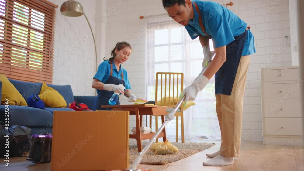 Asian young man and woman cleaning service worker work in living room. Asian young man and woman cleaning service worker work in living room.
