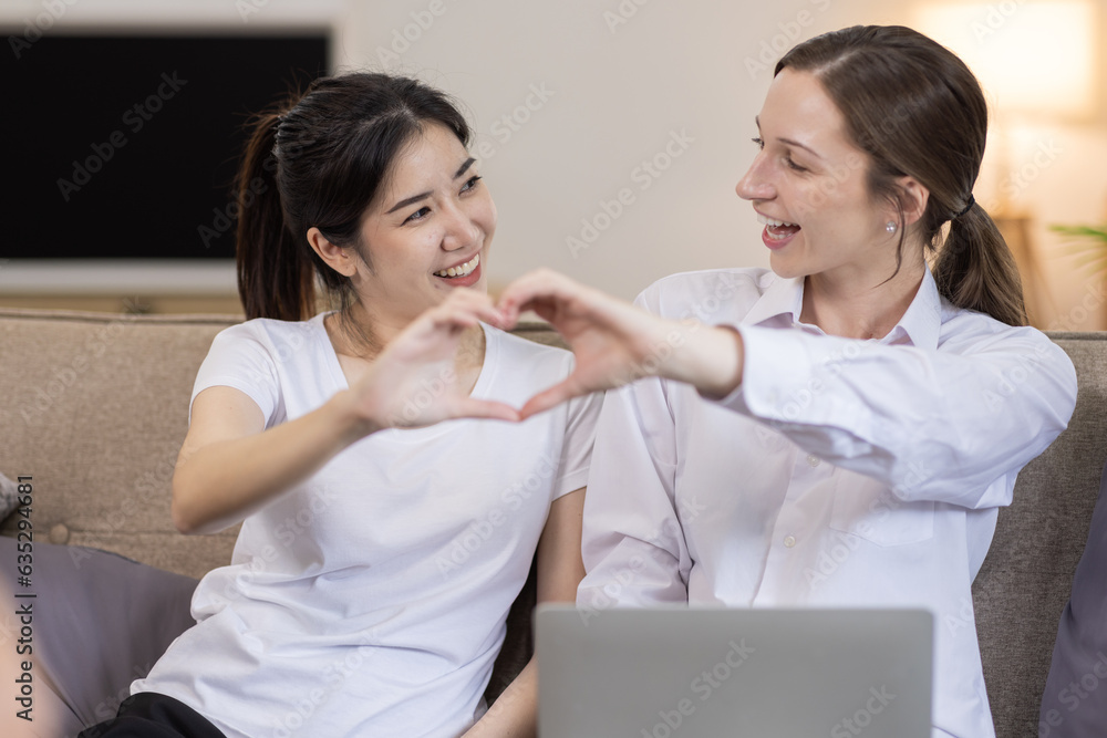 Two Happy asian Ladies Using Laptop Computer Working And Learning Online Together Or Making Video Call Sitting At on sofa in home . E-Learning. Females Entrepreneurship Career Concept. Two Happy asian Ladies Using Laptop Computer Working And Learning Online Together Or Making Video Call Sitting At on sofa in home . E-Learning. Females Entrepreneurship Career Concept.