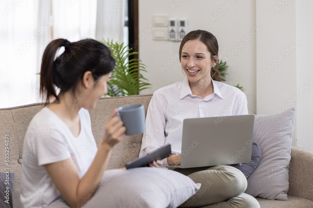 Two Happy asian Ladies Using Laptop Computer Working And Learning Online Together Or Making Video Call Sitting At on sofa in home . E-Learning. Females Entrepreneurship Career Concept. Two Happy asian Ladies Using Laptop Computer Working And Learning Online Together Or Making Video Call Sitting At on sofa in home . E-Learning. Females Entrepreneurship Career Concept.