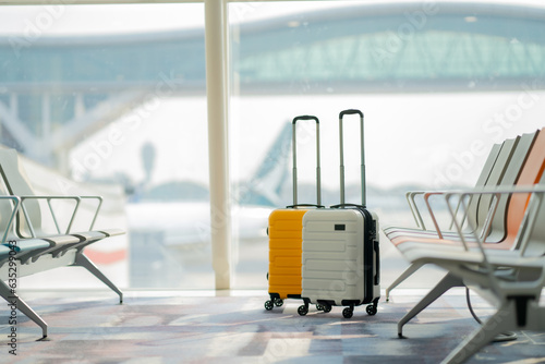 Two suitcases in an empty airport hall, traveler cases in the departure airport terminal waiting for the area, vacation concept, blank space for text message or design