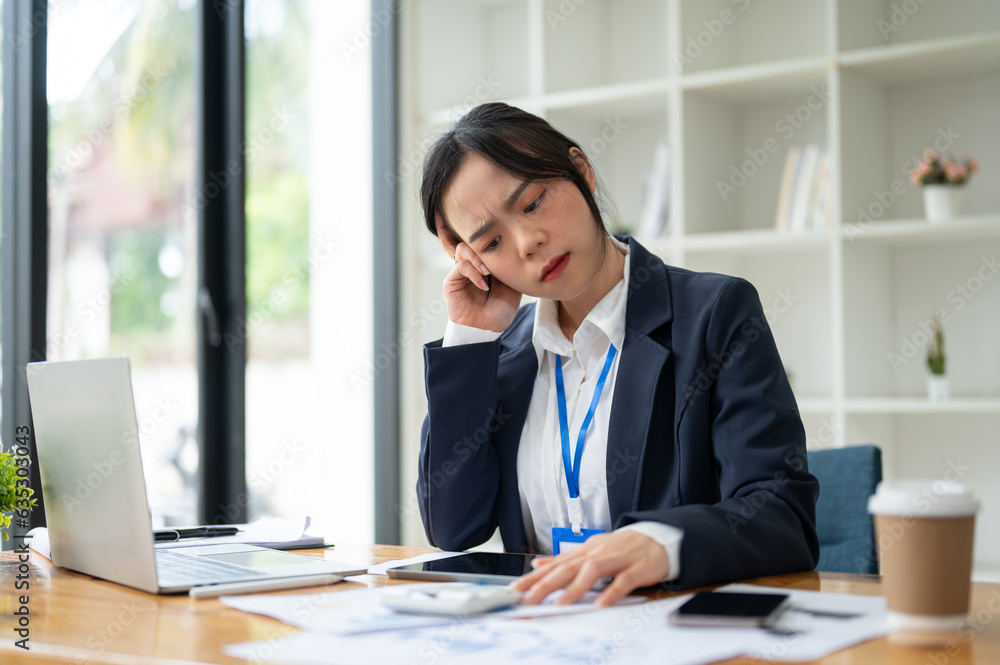 A confused Asian businesswoman reading report with a doubtful face, analyzing financial data A confused Asian businesswoman reading report with a doubtful face, analyzing financial data