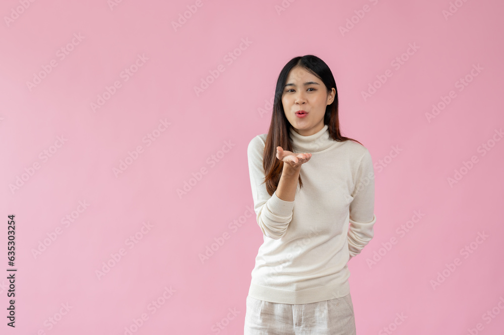 A beautiful Asian woman is standing with a blowing kiss, sending kiss gesture A beautiful Asian woman is standing with a blowing kiss, sending kiss gesture