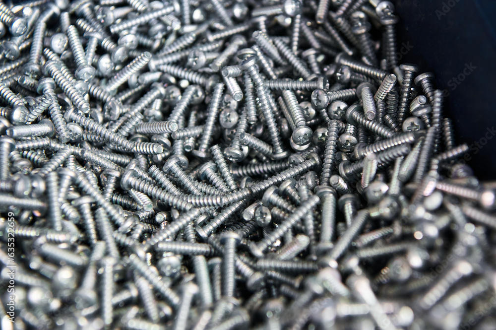Metal screws in container on workbench at car service Metal screws in container on workbench at car service