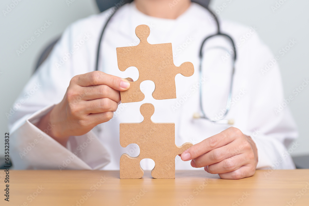 Doctor hand connecting couple puzzle piece, wooden jigsaw in hospital. Teamwork, Idea, Solution, challenge, success, Health, Medical and strategy concepts Doctor hand connecting couple puzzle piece, wooden jigsaw in hospital. Teamwork, Idea, Solution, challenge, success, Health, Medical and strategy concepts