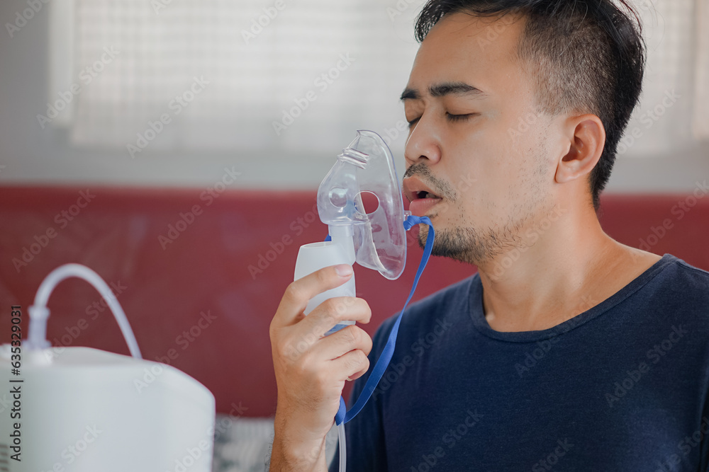Asian boy wearing oxygen mask. man using asthma inhaler while sitting at home due to allergy. Asia man using spray asthma.
Asian boy wearing oxygen mask. man using asthma inhaler while sitting at home due to allergy. Asia man using spray asthma.