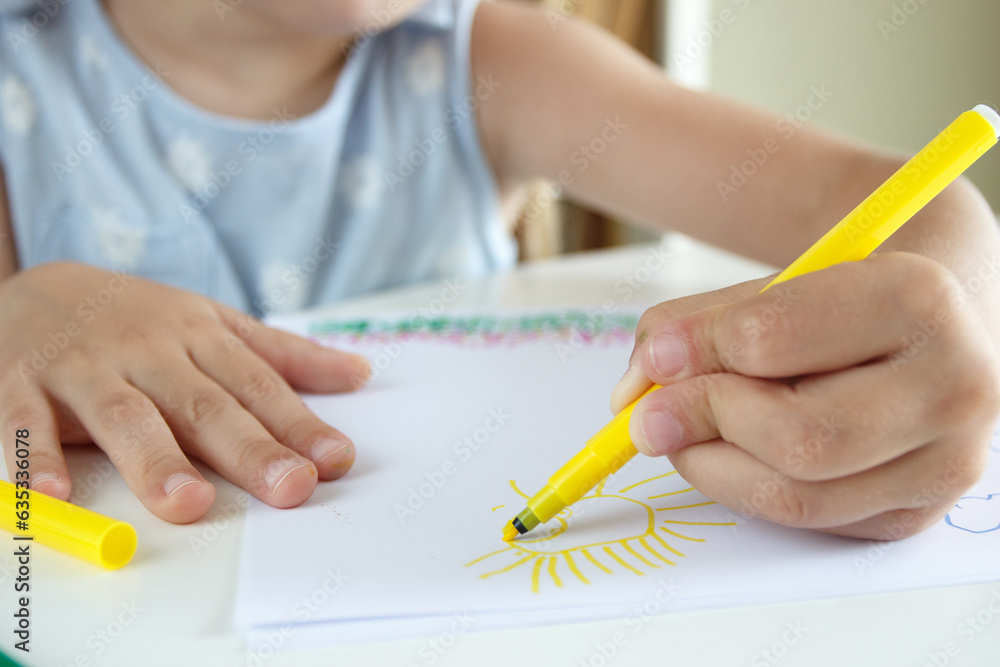 Cute child drawing a picture with colored felt-tip pens. Concept of hobby Cute child drawing a picture with colored felt-tip pens. Concept of hobby