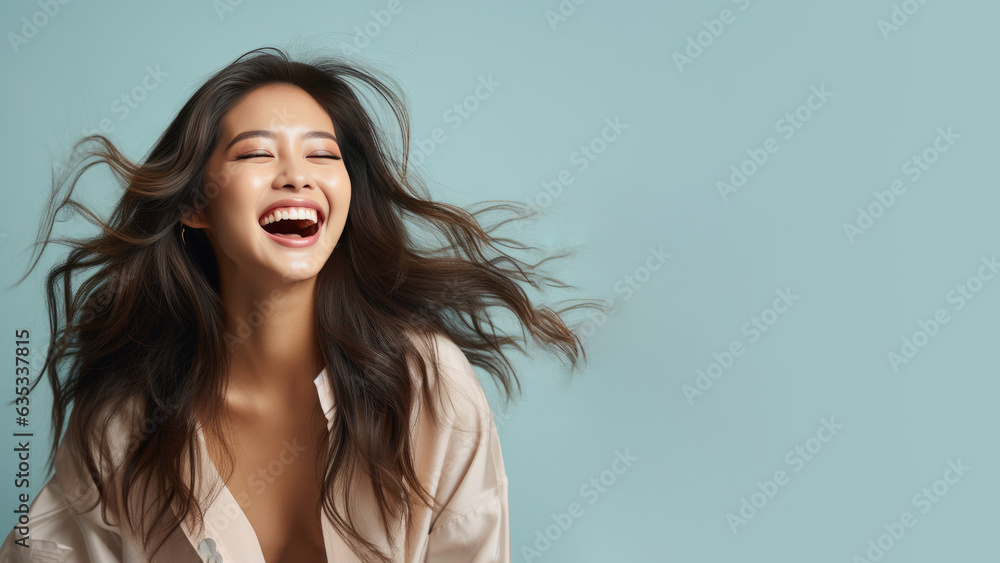 Happy chinese girl is laughing out loud isolated on pastel background with copy space Happy chinese girl is laughing out loud isolated on pastel background with copy space