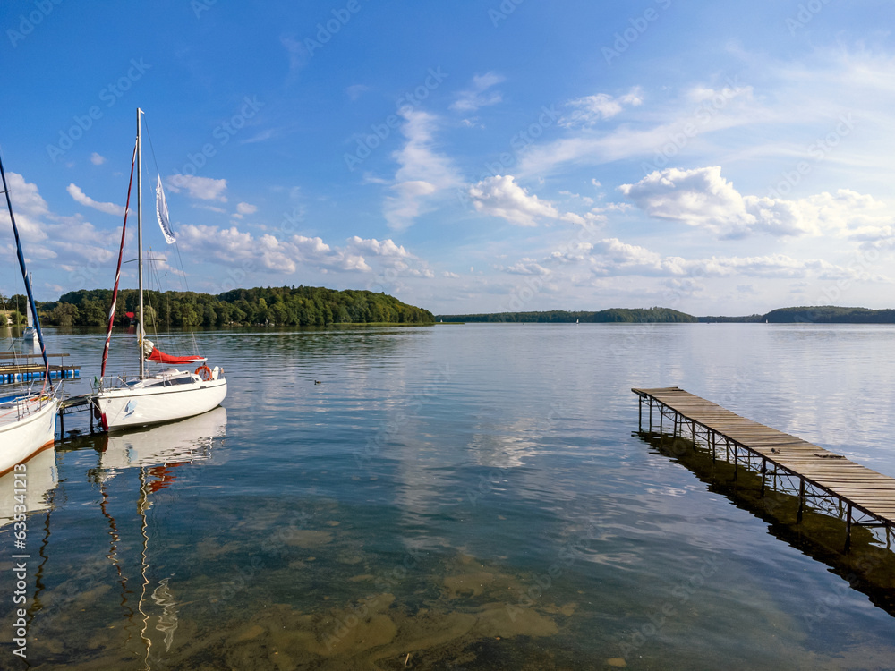 View of the marina, wooden footbridge , lake, boat, forest and nature.