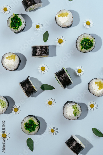 Classic Japanese sushi rolls are laid out on a blue background w photo