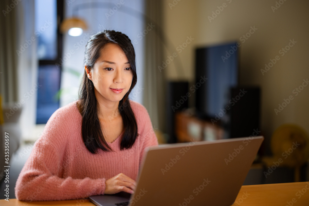 Woman work on laptop computer at home in the evening Woman work on laptop computer at home in the evening