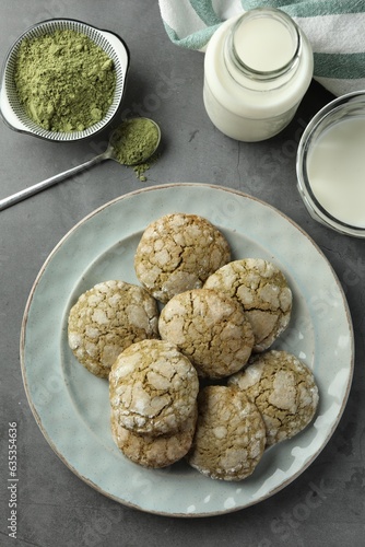 Tasty matcha cookies, powder and milk on grey table, flat lay