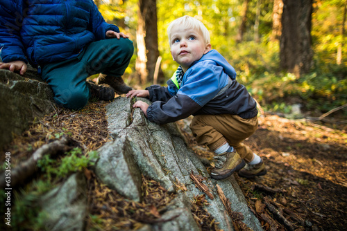 Boys climbing, exploring and playing outdoors in nature. photo