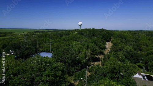 A Long Approaching Tree Top Drone Shot of the Vintage Killarney Manitoba Historic Shamrock Water Tower Structure by Killarney Lake in Western Canada. photo