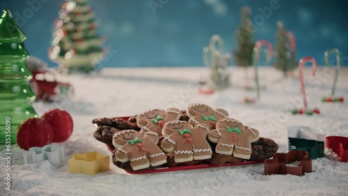 Gingerbread Men Sitting On a Plate in a Snowing Winter Wonderland photo