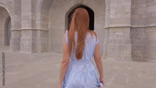 Stunning footage of a girl walking into an entrance of the temple of The sacred Heart of Jesus located on the summit of Mount Tibidabo in Barcelona. This church was designed by Enric Sagnier. photo