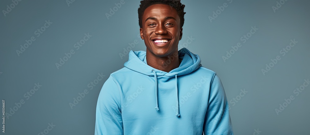 Fototapeta premium Dark skinned American man friendly in blue sweatshirt studio background with copy space