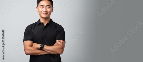 Asian man with black polo smiling hand on waist white backdrop with copy space on palm
