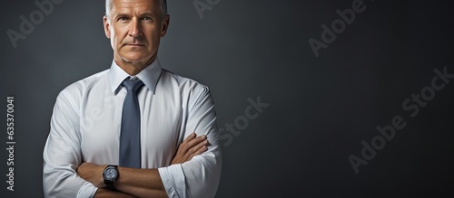 Studio half portrait of a senior man in a shirt and tie standing with arms crossed against an isolated background Side profile with copy space