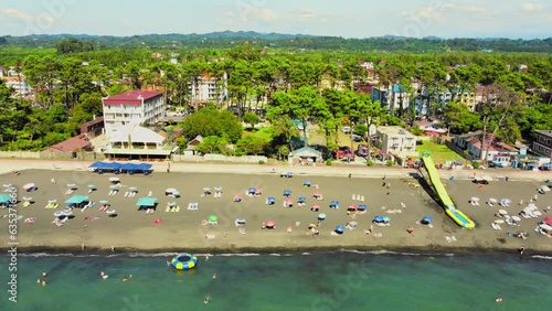 Aerial view of beach and umbrellas. Stay. Beach and blue water. Drone view of beach and the azure sea in Georgia Chakvi View of Black Sea coast. Beach coastline - summer day, people swim, sunbathe photo