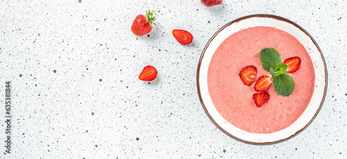 Sweet creamy strawberry soup on a light background. Long banner format. top view