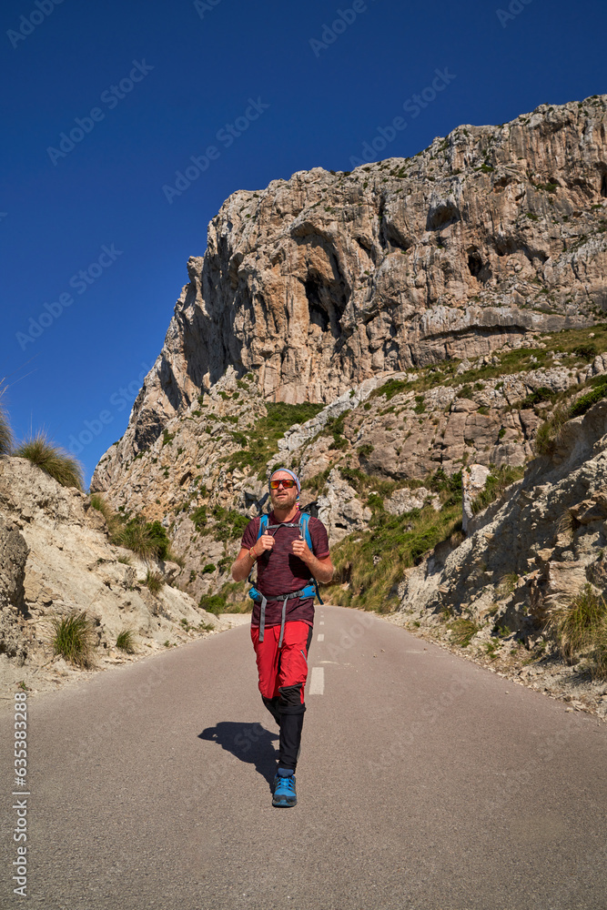 Male hiker walking on road in mountains