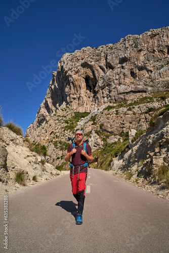 Male hiker walking on road in mountains