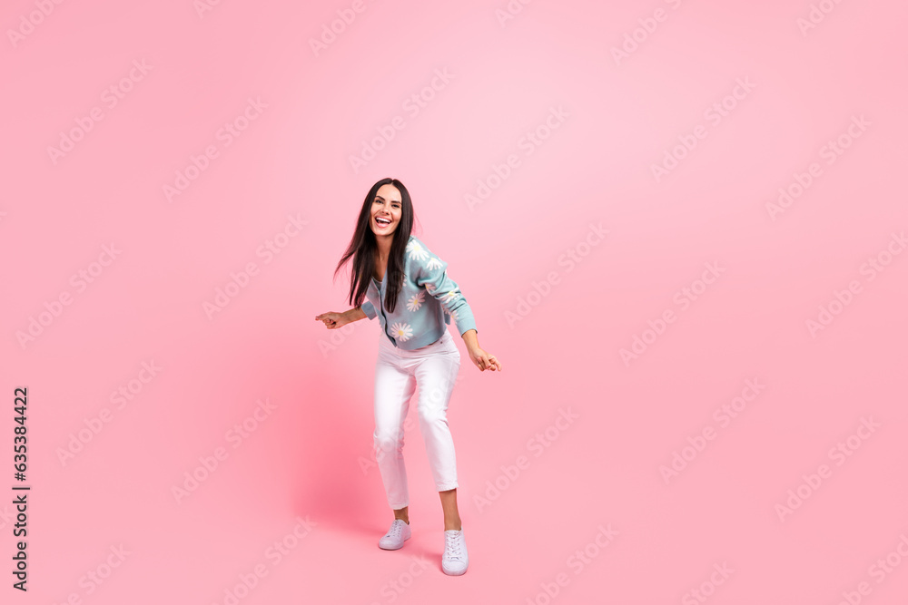 Full length photo of pretty adorable woman dressed blue cardigan dancing empty space isolated pink color background Full length photo of pretty adorable woman dressed blue cardigan dancing empty space isolated pink color background