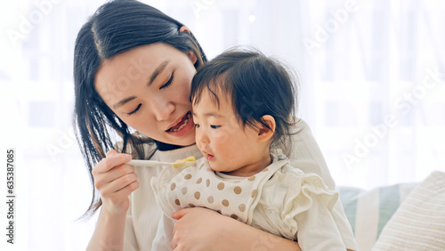 赤ちゃんに離乳食を食べさせるママ photo