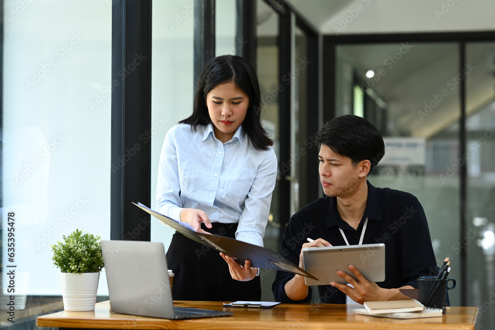 Female manager explaining information, discussing business plan with young businessman Female manager explaining information, discussing business plan with young businessman