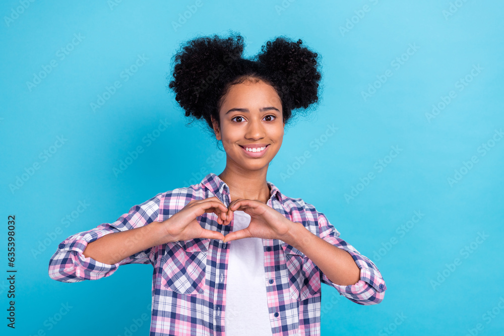 Photo of pretty sweet lady wear checkered shirt showing arms heart smiling isolated blue color background Photo of pretty sweet lady wear checkered shirt showing arms heart smiling isolated blue color background