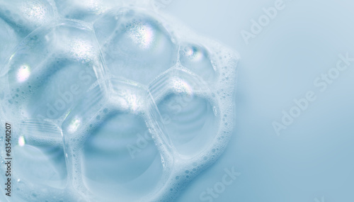 Foam border design on blue background. Liquid soap bubbles, Foam bubbles background. Soap foam popping bubble, white backdrop. Soap sud macro structure. Soap foam close-up. Clean, cleaning, washing. 