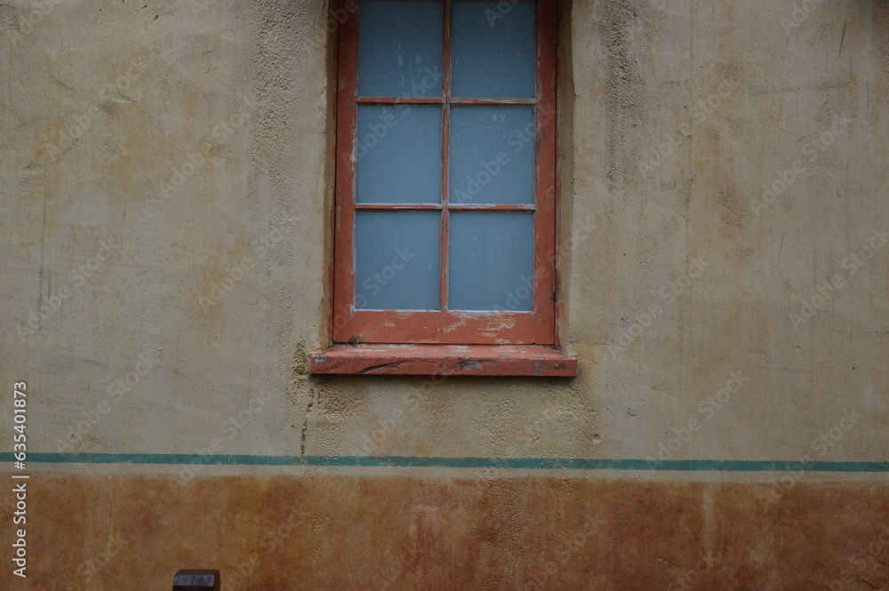 A wooden window in an old plaster stone building
