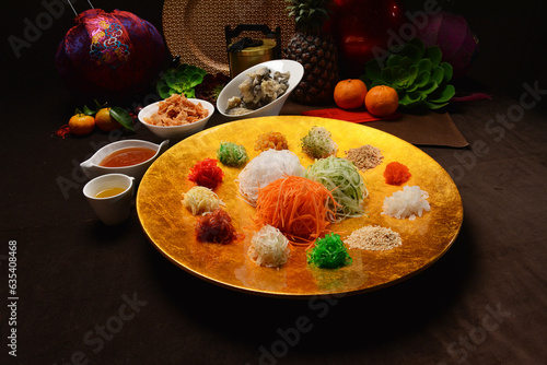 fresh colourful asian festive vegetables salad lo hei yu sheng with smoked salmon, fish skin, cookies and sweet spicy sauce buffet corner for chinese new year halal food menu for banquet restaurant photo