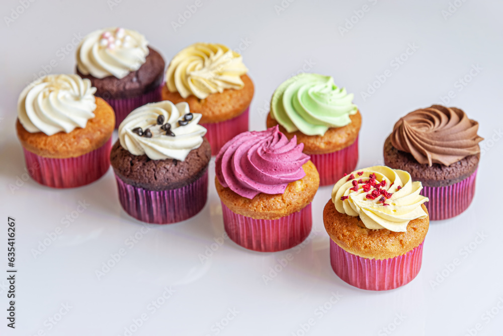 assorted cupcakes on a white glass surface close up