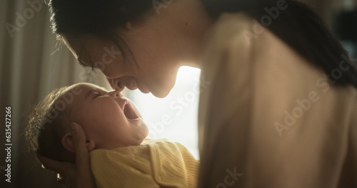Bild auf Leinwand Motherly Affection Concept: Close Up Portrait of a Cute Asian Baby Laughing and Enjoying Bonding Time Together, Looking at Mother with Love