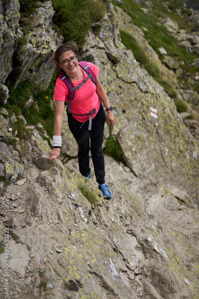 Hiker lady on a trail in the mountains