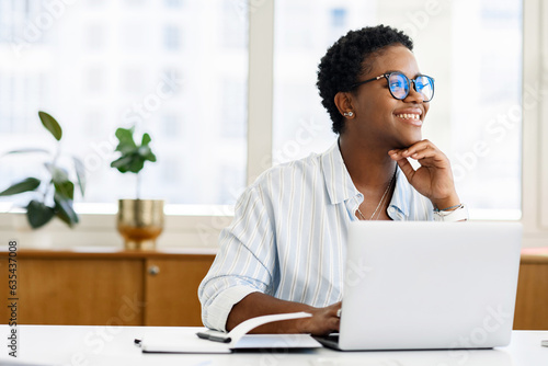 Billede på lærred Portrait of dreamy african american businesswoman sitting at the desk in front o