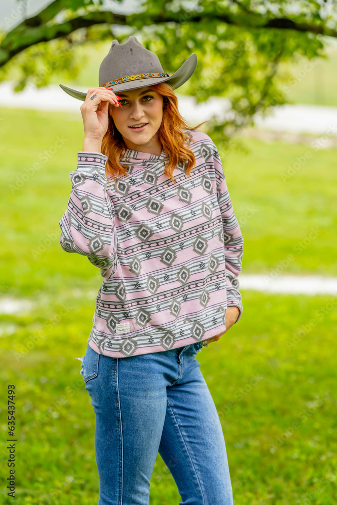 A Lovely Red Headed Country Wetern Model Poses Outdoors In A Country Setting