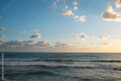 Beautiful seascape of cloudy sky lit by dimming sunset light over the calm sea. Ocean view with horizon  background with a lot of copy space for text.