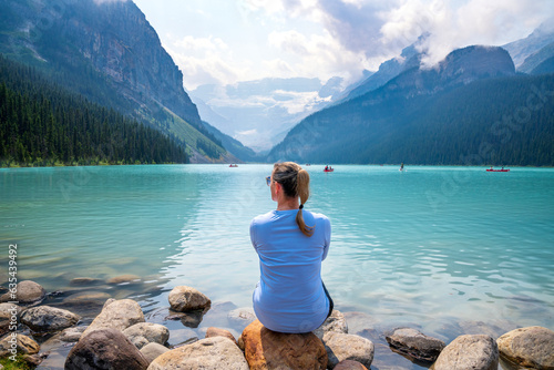 Woman enjoying Lake Louise.Beautiful Nature and Tranquility.Banff National Park, Canadian Rockies, Alberta, Canada...Banff National Park, Alberta, Canada