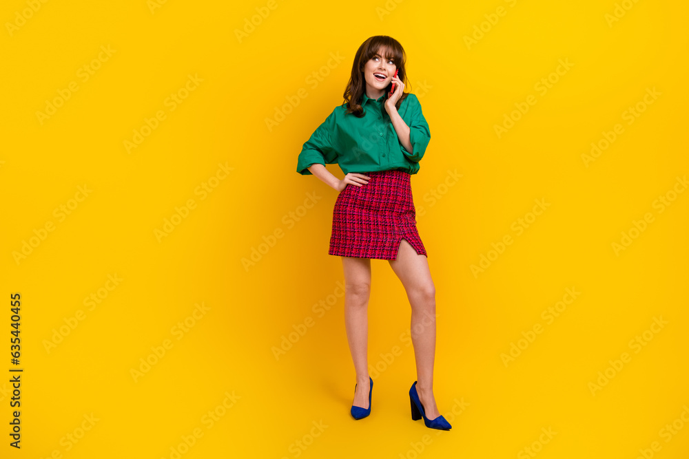 Full body portrait of positive gorgeous lady put arm waist speak communicate telephone isolated on yellow color background Full body portrait of positive gorgeous lady put arm waist speak communicate telephone isolated on yellow color background
