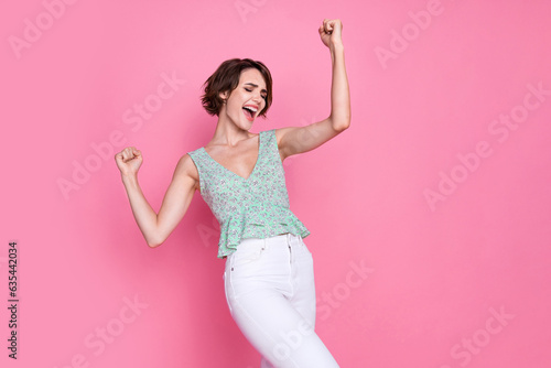 Portrait of awesome young charming woman raise fists up screaming lucky yelling champion best competitor isolated on pink color background