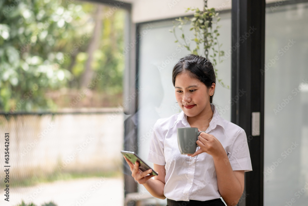 Happy businesswoman using the phone during break with coffee Happy businesswoman using the phone during break with coffee
