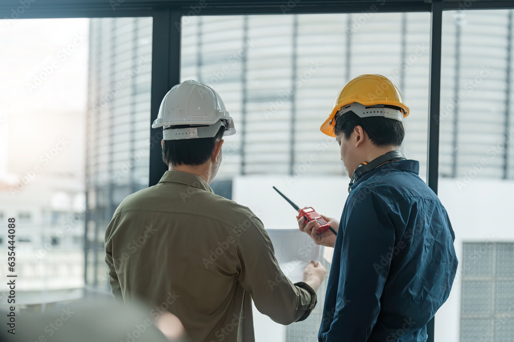 Two engineer man checking work with walkie-talkie for communication in the construction site Two engineer man checking work with walkie-talkie for communication in the construction site