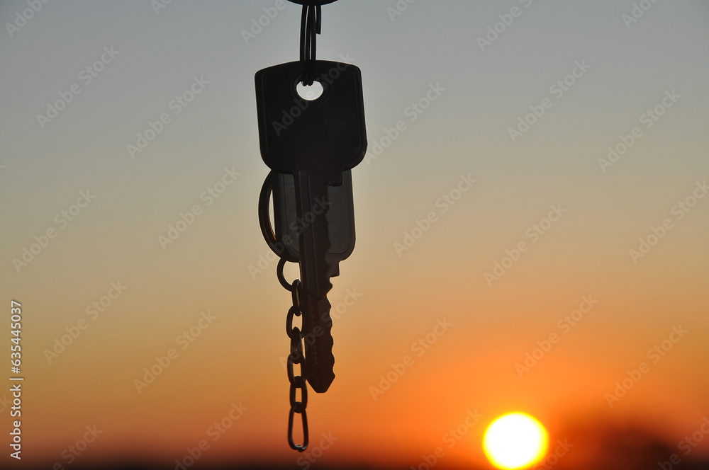 Fototapeta premium silhueta de chave em lindo por do sol, conquista e negócios imobiliários, aluguel ou casa própria 