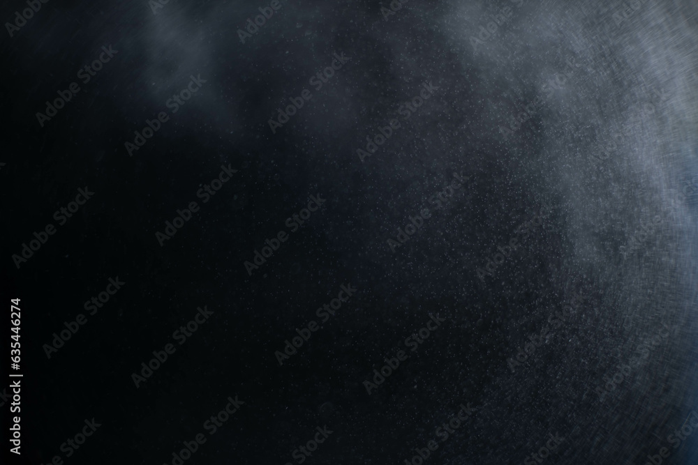 Water spray dust on dark background. Spraying mist effect isolated on black background.