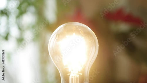 One Person Screws a Led Light Bulb in the Socket and Turn On the Light in the Room. Saving Energy Concept Using Led Bulb.