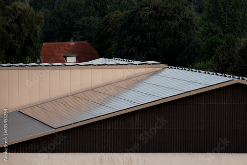 Warehouse with solar panels on the roof. Nature-produced energy. Sun-produced energy. Photovoltaic systems on the barn house in the countryside. Semiconductor technology. Carbonless footprint.